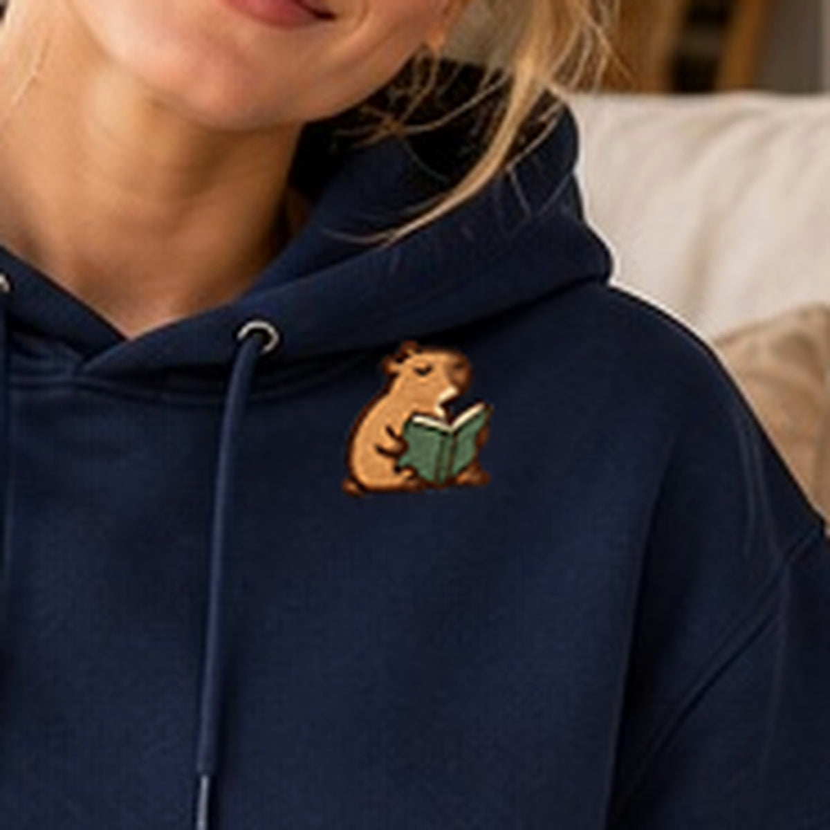 Detailansicht der Stickerei: Lesendes_Mellowbara – Kapuzenpullover mit kleiner Stickerei, nachgeschärft