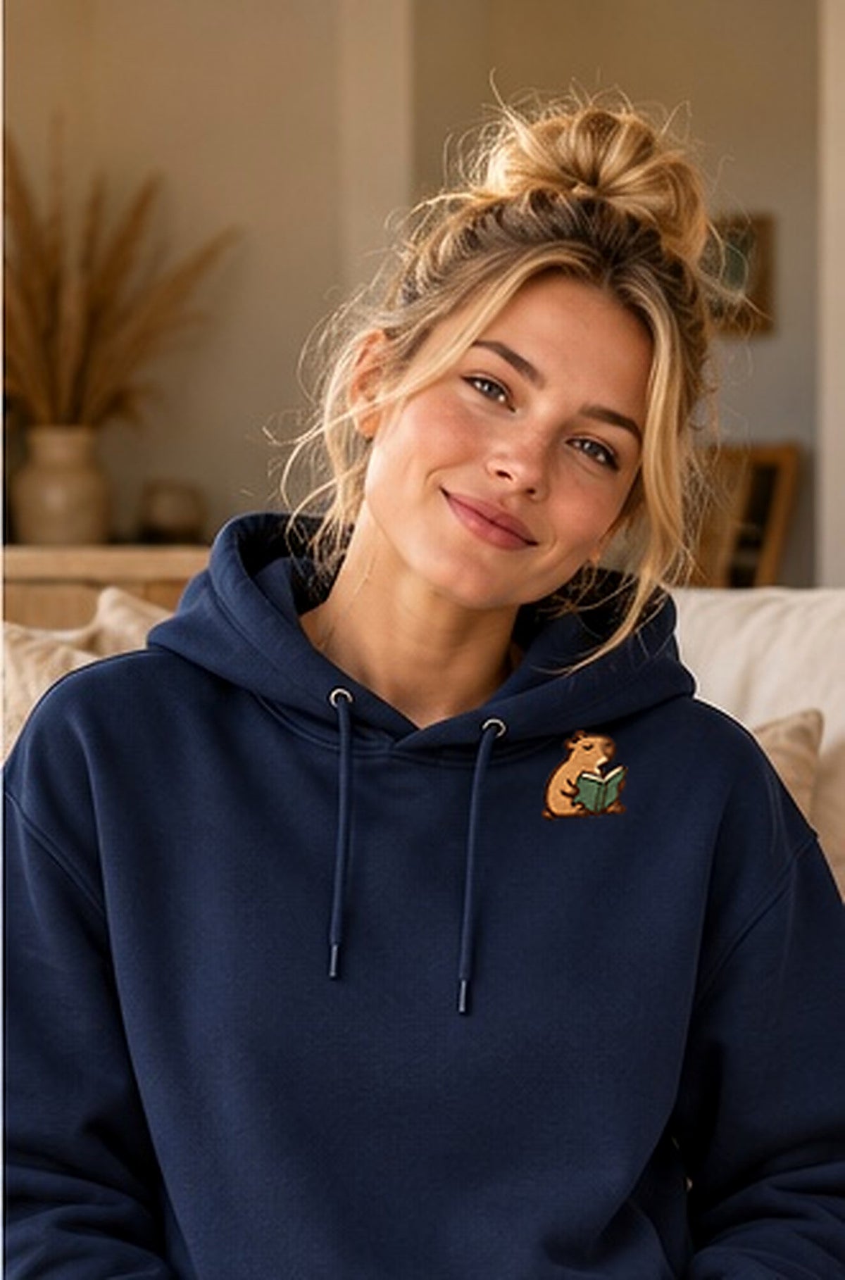 Lifestyle-Foto: Lesendes_Mellowbara – Kapuzenpullover mit kleiner Stickerei getragen, nachgeschärfte Produktaufnahme